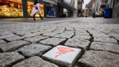 Mit über 150 in den Boden eingelassene Keramik-Rosen wird in Hildesheim ein Rundgang durch die Stadt markiert. (Foto: Julian Stratenschulte/dpa)