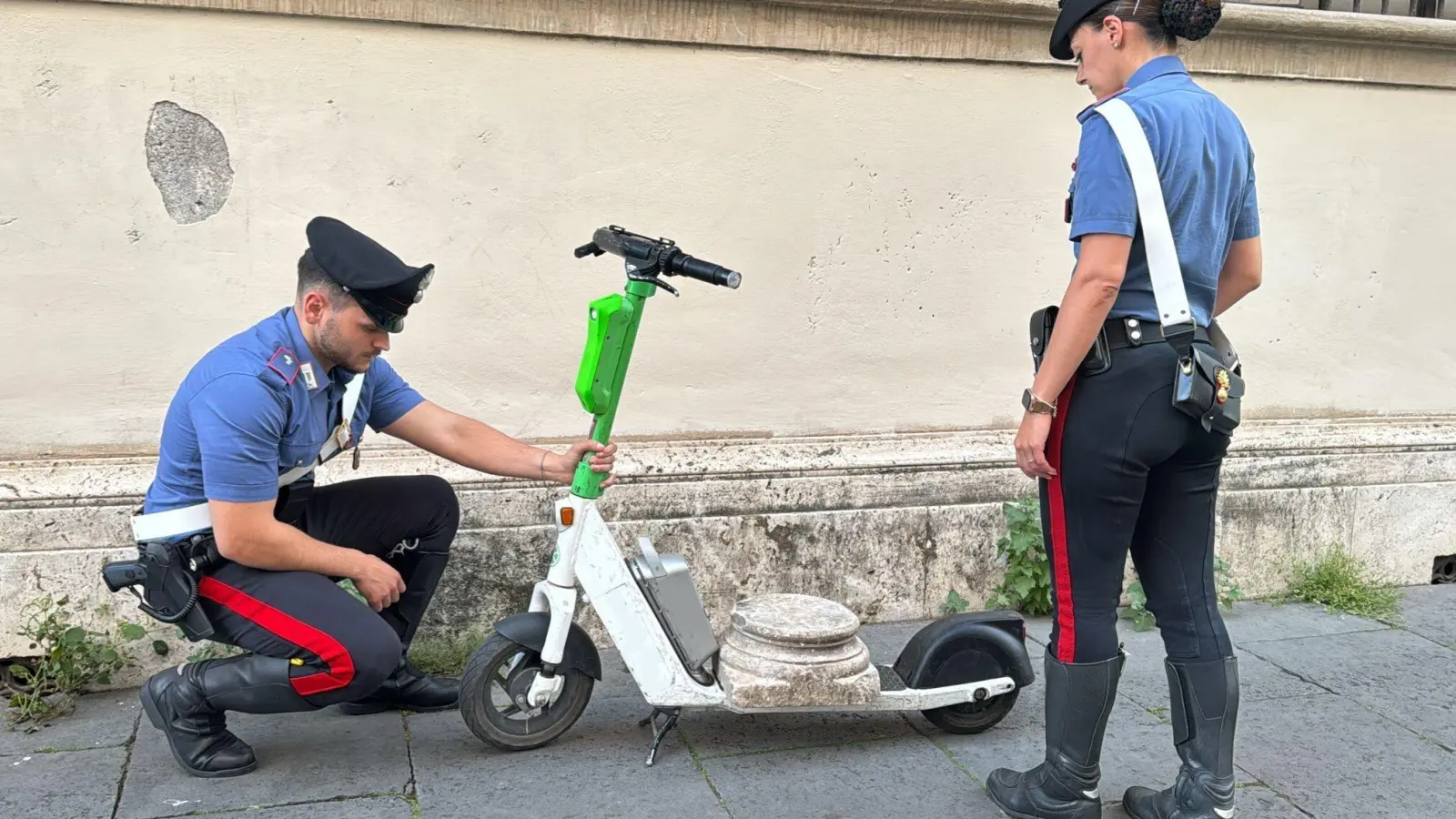 Zwei Carabinieri begutachten den Marmorsockel auf einem elektrischen Leihroller. (Foto: ---/Comando Generale Dell’arma Dei/dpa)