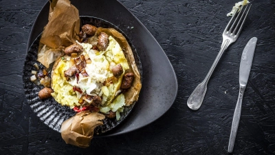 Kumpir ist ein typisches türkisches Streetfood. Mit Merguez und Sauerkraut wird aus der Ofenkartoffel ein würzig-frisches Gericht. (Foto: KMG/die-kartoffel.de/dpa-tmn)