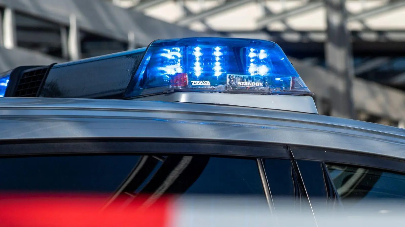 Ein Polizei-Blaulicht leuchtet über einem Absperrband mit der Aufschrift „Polizeiabsperrung“. (Foto: David Inderlied/dpa/Illustration)