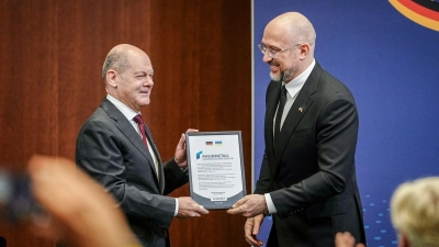 Der ukrainische Premierminister Denys Schmyhal überreicht Bundeskanzler Olaf Scholz beim 6. Deutsch-Ukrainischen Businessforum der DIHK ein Zertifikat für die Rheinmetall Joint-Venture Registrierung für die Ukraine. (Foto: Kay Nietfeld/dpa)