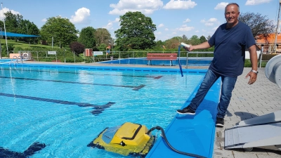 Freibad-Chef Stefan Keller setzt „Das Boot“ ins Wasser des Nicht-Schwimmer-Beckens. Der Roboter reinigt regelmäßig die Becken im Burgbernheimer Freibad. (Foto: Katrin Merklein)