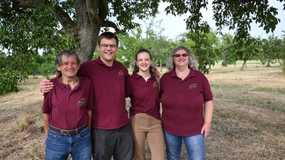 Walter Henninger, Ruben Henninger, Lea-Sofia Henninger und Karola Henninger (von links) stehen unter einem ihrer zwei 200 Jahre alten Birnbäume. Er trägt immer noch Früchte, die sich fürs Brennen eignen. (Foto: Anna Beigel)