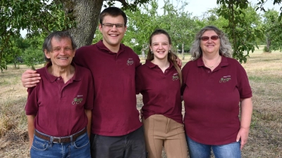 Walter Henninger, Ruben Henninger, Lea-Sofia Henninger und Karola Henninger (von links) stehen unter einem ihrer zwei 200 Jahre alten Birnbäume. Er trägt immer noch Früchte, die sich fürs Brennen eignen. (Foto: Anna Beigel)