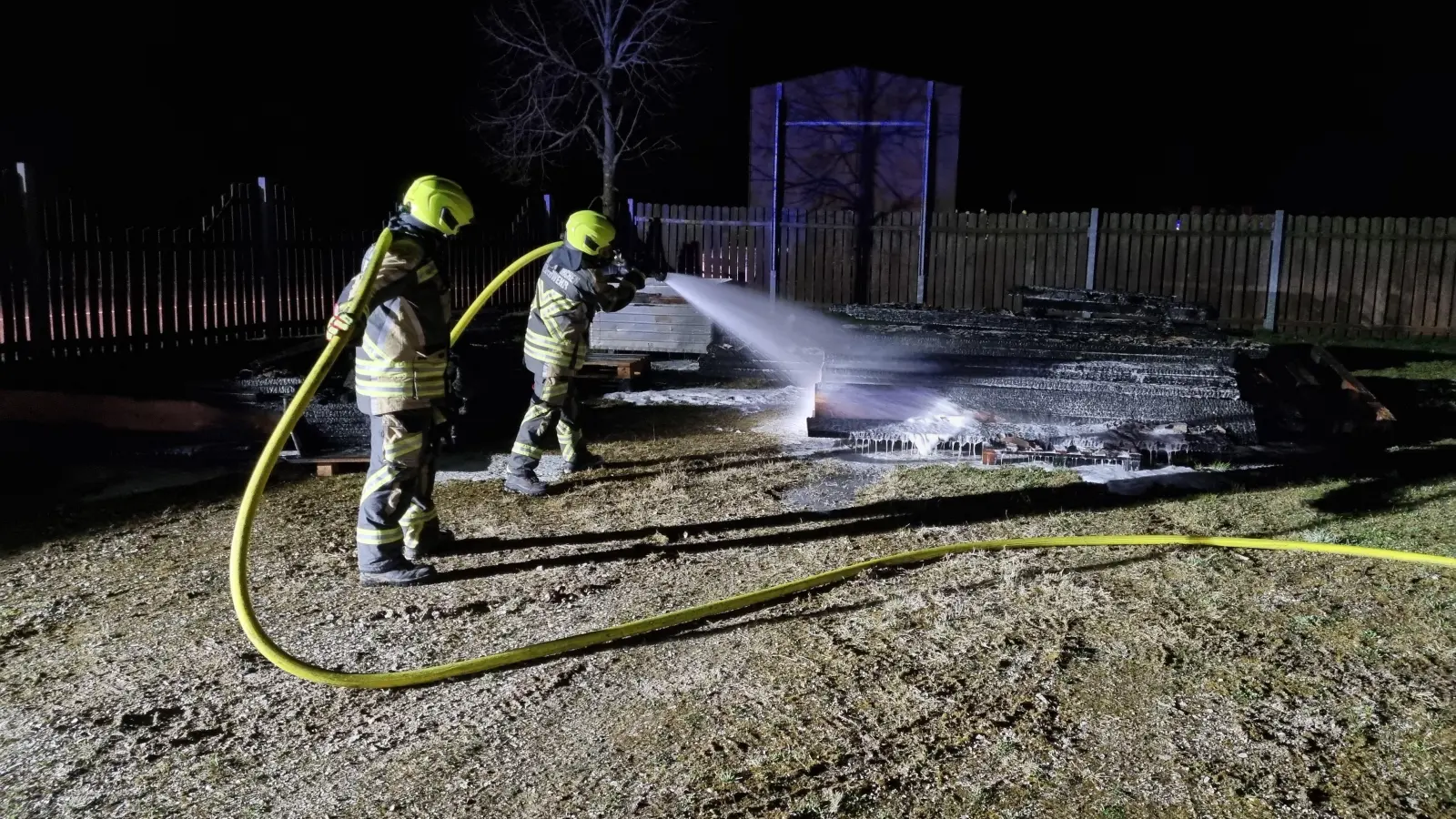 Die Bretter aus dem Holzlager wurden anschließend ebenfalls abgelöscht. (Foto: Kreisfeuerwehrverband Neustadt/Rainer Weiskirchen)