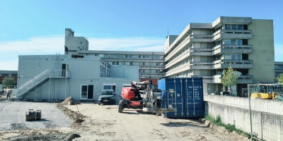Über die Container links im Bild wird man ab Mitte des Jahres ins Krankenhaus in Ansbach kommen. Der B-Trakt (rechts im Bild) wird abgerissen und durch einen Neubau ersetzt.  (Foto: Robert Maurer)