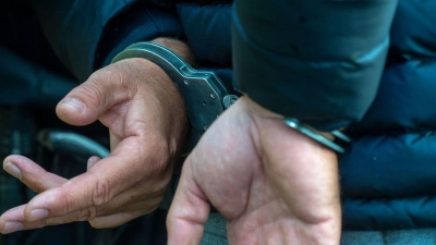 Ein Mann trägt Handschellen. (Foto: Stefan Sauer/dpa/Illustration)