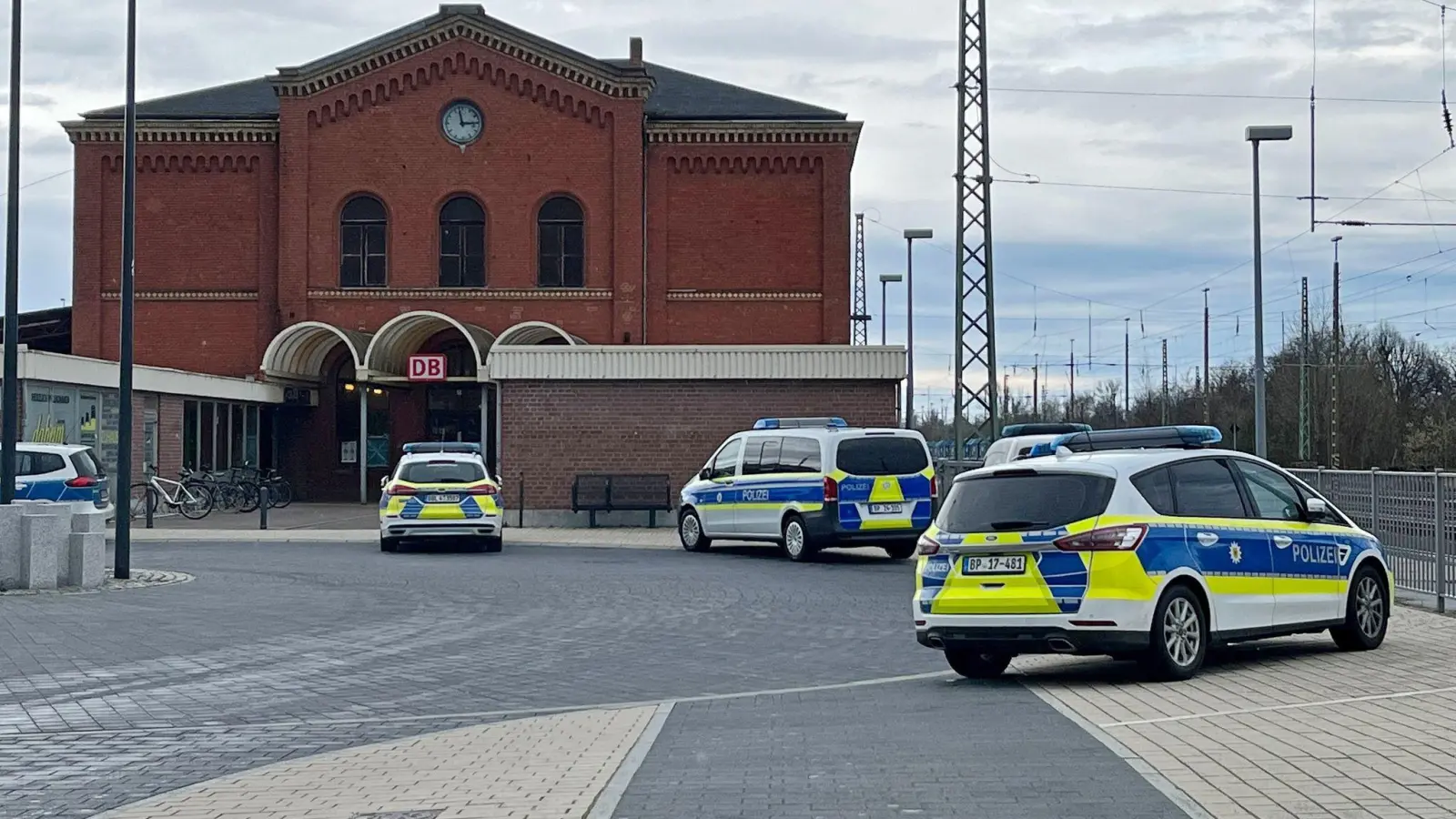 Polizeifahrzeuge vor dem Bahnhof in Guben. Ein Mann hat in einem Regionalzug in Brandenburg eine Jugendliche mit einem axtähnlichen Gegenstand verletzt. (Foto: Ute Richter/dpa)