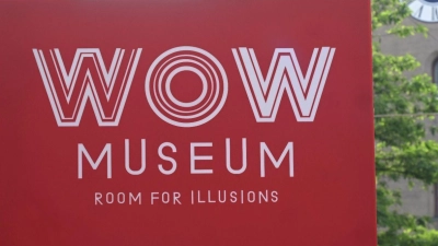 Das Schild des „WOW Museum - Room for Illusions“ hängt im Tal am Eingang des Museums in der Nähe des Isartors. Das neue Museum wird 16 Erlebnisräume mit optischen Täuschungen und interaktiven Exponaten bieten. (Foto: Felix Hörhager/dpa)