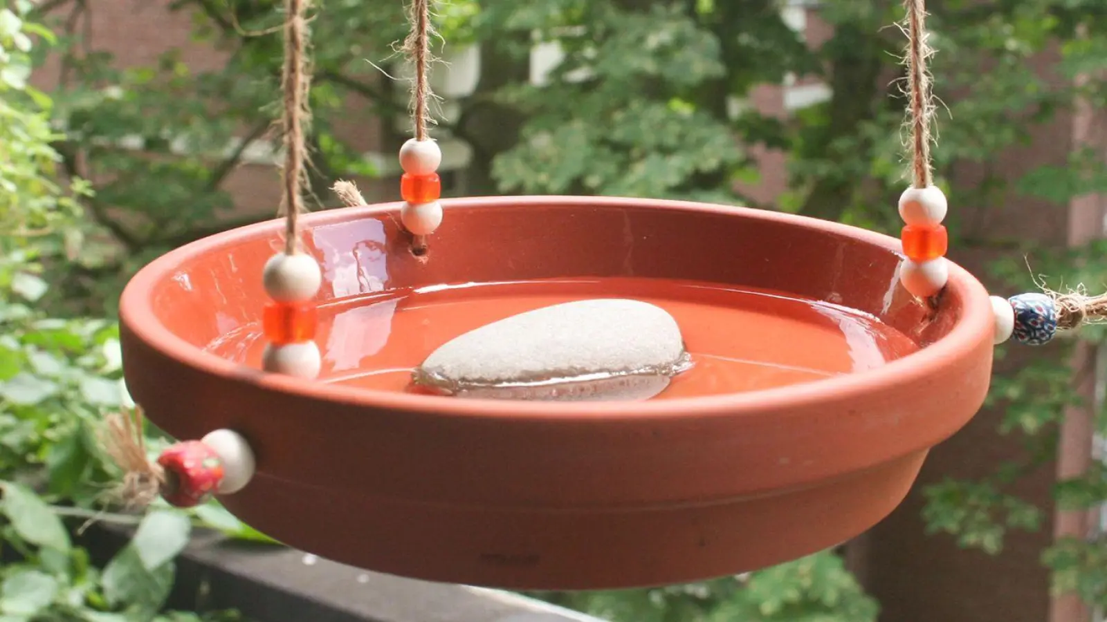 Drei Löcher, ein paar Schnüre: So wird aus einem Tonuntersetzer eine nützliche Trinkstelle für Vögel. (Foto: Steffen Rieger/DIY Academy e.V./dpa-tmn)
