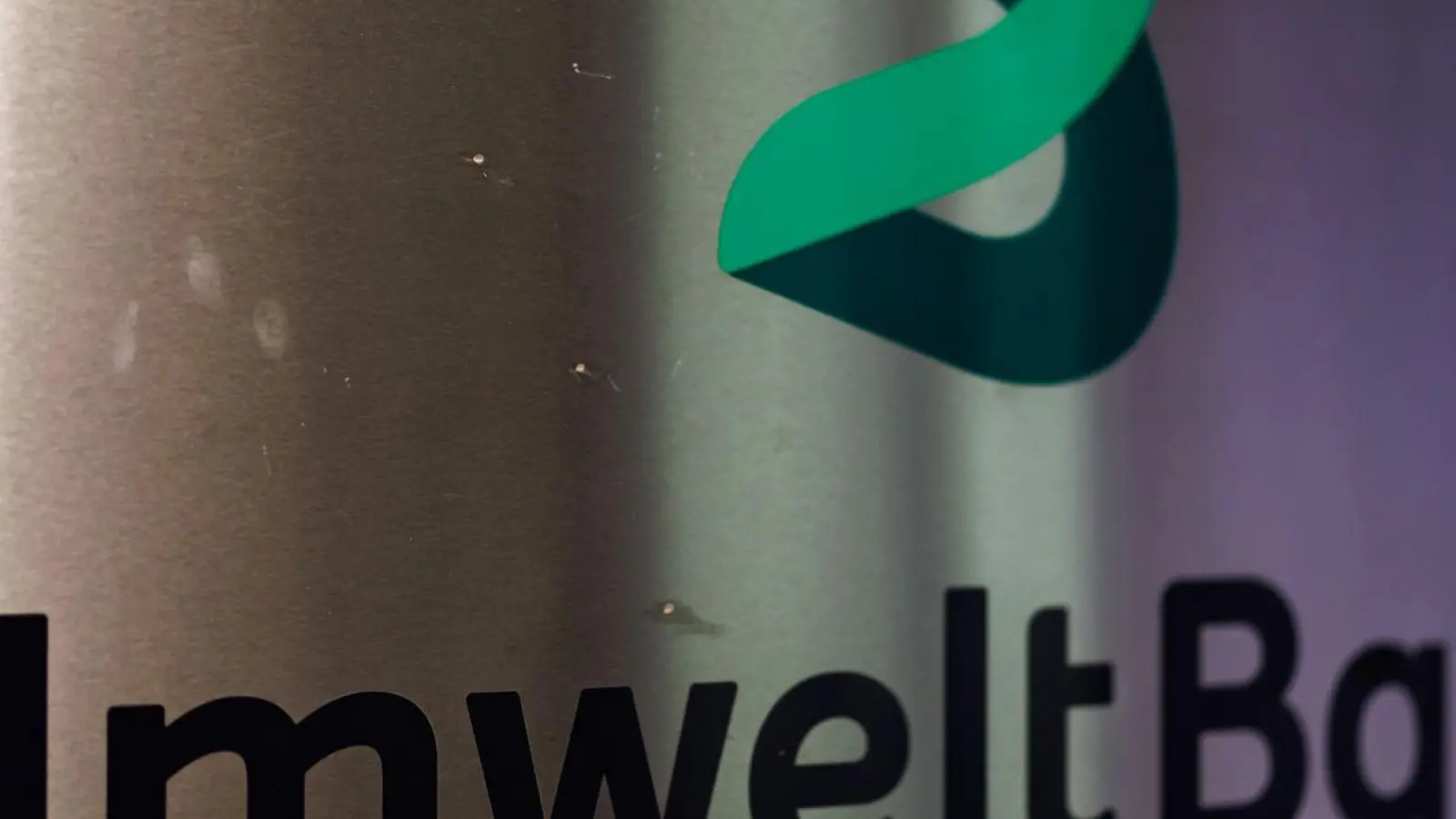 Das Logo der UmweltBank AG steht auf einem Schild am Eingang am Sitz des Unternehmens. (Foto: Daniel Karmann/dpa)