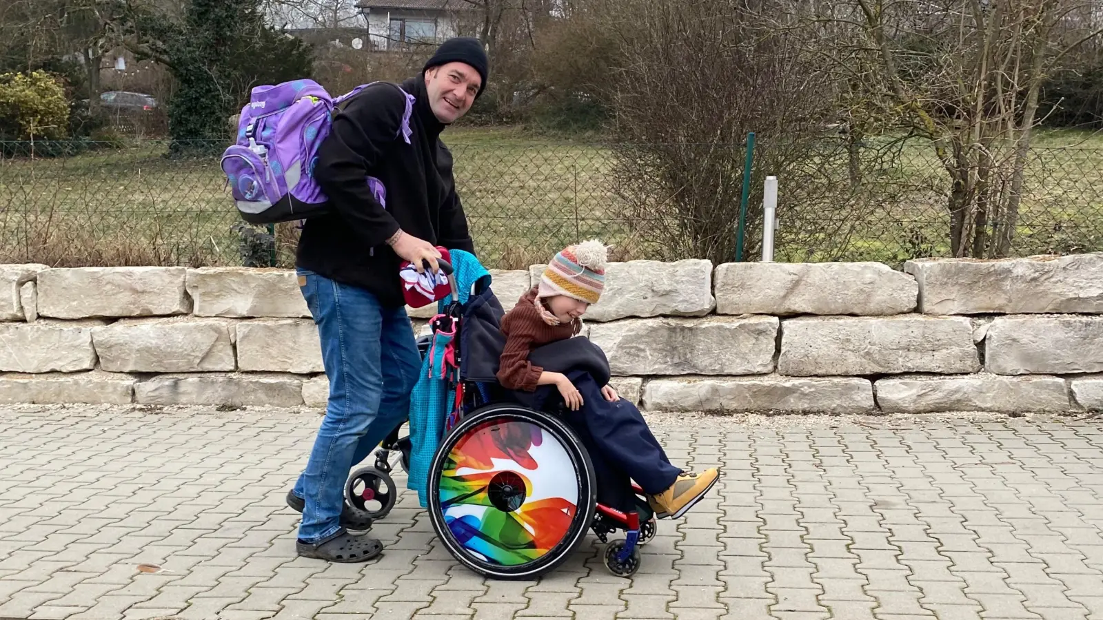 Mit dem Bus ist Tina Lux gerade von der Schule zurück nach Dagenbach gekommen. Markus Lux schiebt die Achtjährige zum Haus. Bis jetzt hat sie nur den Rollstuhl, um sicher sitzen zu können. (Foto: Manfred Blendinger)