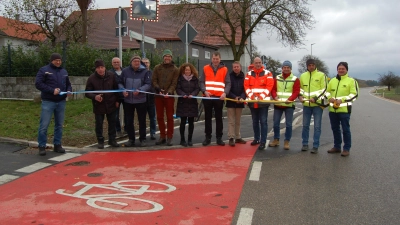 Symbolischer Akt am Ortsausgang von Bergheim: Mit dem Durchschneiden des Bandes wurde der Geh- und Radweg freigeben. Mit im Bild sind Tannhausens Bürgermeister Siegfried Czerwinski (Fünfter von rechts) und Wilburgstettens Rathauschef Michael Sommer (Achter von rechts). (Foto: Markus Weinzierl)