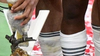 Bayern-Trainer Vincent Kompany stellt bei der Meisterparty eine Kakadu-Figur auf den Sockel. (Foto: Sven Hoppe/dpa)