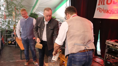 Mit zwei Schlägen zapfte Oberbürgermeister Thomas Deffner (Mitte) das erste Fass Bier des Ansbacher Frühlingsfestes 2026 an. (Foto: Alexander Biernoth)