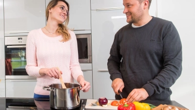 Ein Lächeln hier, etwas Schäkern da: Geht es am Anfang einer Beziehung noch harmonisch am Herd zu, kann die Küche später schon mal zur Kampfzone werden.  (Foto: Benjamin Nolte/dpa-tmn)