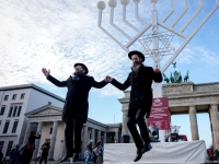 Yehuda Teichtal (l), orthodoxer Rabbiner, und Rabbi Shmuel Segal tanzen bei der Einweihung des Chanukka-Leuchters am Brandenburger Tor in Berlin. (Foto: Kay Nietfeld/dpa)