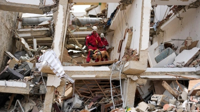 Rettungskräfte aus Spanien durchsuchen die Trümmer eines Gebäudes. (Foto: Fernando Vergara/AP/dpa)
