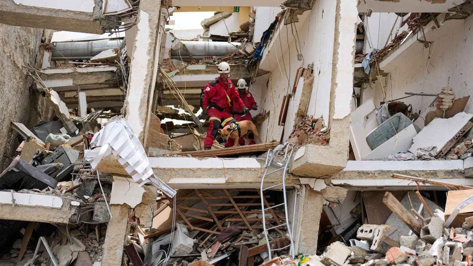 Rettungskräfte aus Spanien durchsuchen die Trümmer eines Gebäudes. (Foto: Fernando Vergara/AP/dpa)