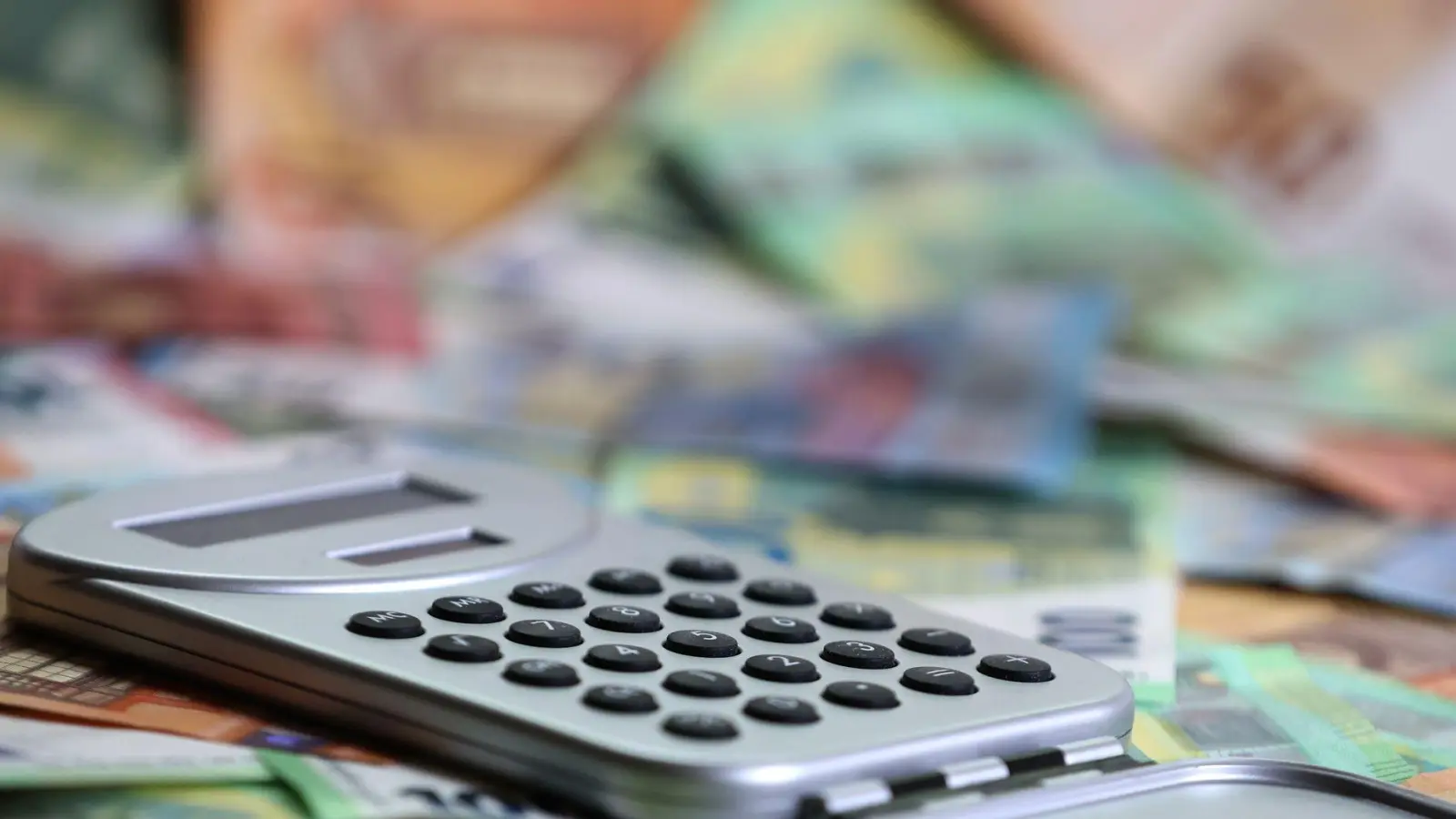 Ein Taschenrechner liegt auf verschiedenen Euro-Banknoten. (Symbolbild) (Foto: Karl-Josef Hildenbrand/dpa)