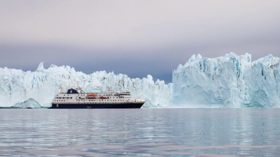 Vor so großen Eisbergen wirkt ein Schiff wie die „MS Spitsbergen“ ziemlich klein. (Foto: Verena Wolff/dpa-tmn)