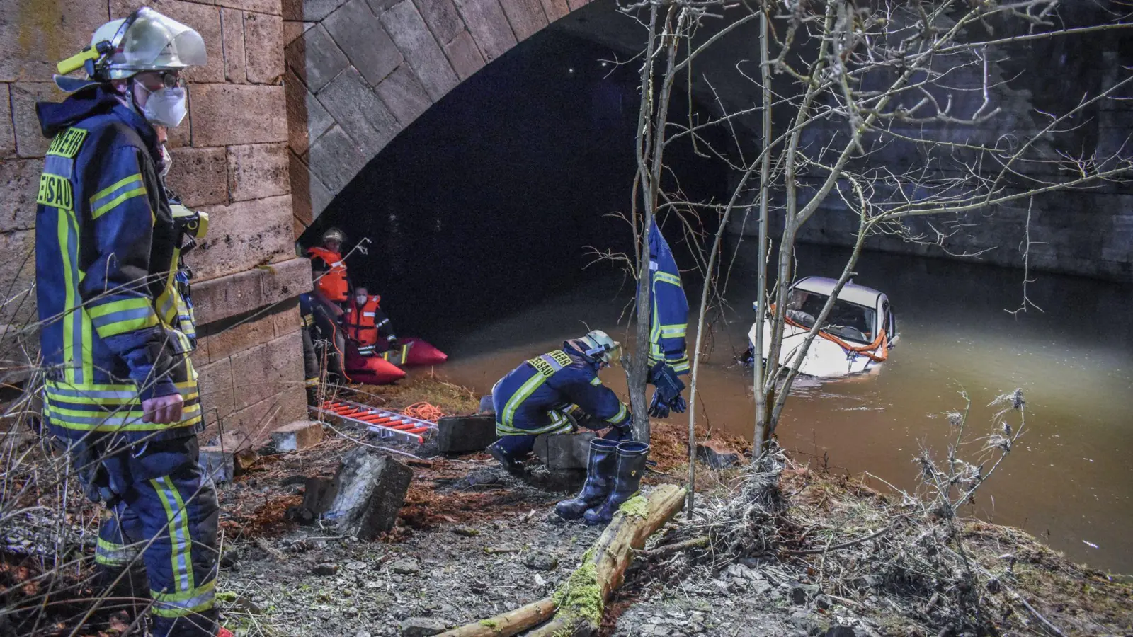 Das Auto liegt unterhalb der Brücke am Fluss Kocher in Künzelsau. (Foto: Fabian Koss/onw-images/dpa)