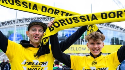 Zwei Fans von Borussia Dortmund stehen mit einem BVB-Fan-Schal vor dem Wembley-Stadion. (Foto: Tom Weller/dpa)