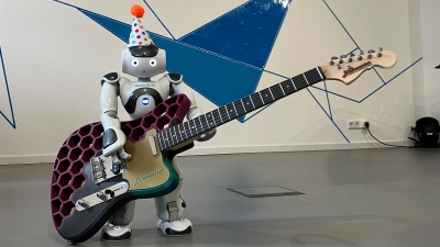 Roboter NAO vom BayernLab hat sich eine Gitarre aus dem 3D-Drucker umgeschnallt. (Foto: BayernLab/ Christian Schweigert)