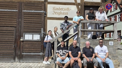 Wie regionales Brauchtum gepflegt wird, erfuhren Schülerinnen und Schüler der Berufsintegrationsklasse bei einem Besuch im Zeughaus der Kinderzeche. Einen Einblick in das Heimatfest gab Festspieler Robert Hippelein (vorne, Zweiter von rechts). Die jungen Leute wurden von den Lehrkräften Claudia Geißler-Kraft (auf der Treppe rechts) und Dr. Martin Nipp (vorne, Zweiter von links) begleitet.  (Foto: Markus Weinzierl)