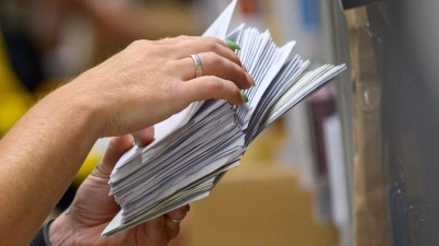 Noch werden massenhaft Briefe verschickt in Deutschland - aber wie lange noch? Hier eine Post-Mitarbeiterin in einem Zustellstützpunkt bei der Arbeit. (Foto: Klaus-Dietmar Gabbert/dpa)