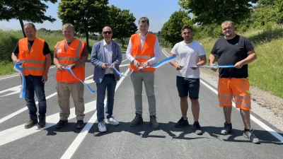 Die Straße ist zum Wochenende wieder nutzbar. Vorher wurde das symbolische Band durchschnitten. Eine der Scheren führte Bürgermeister Michael Trzybinski (Dritter von links). (Foto: Bettina Dworatzek)