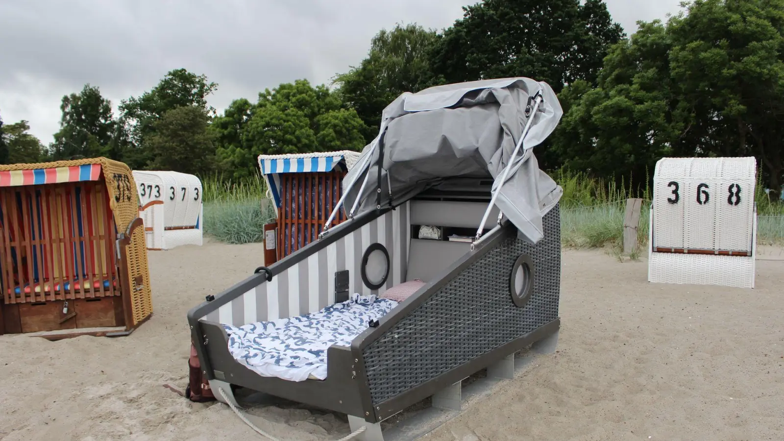 Zwischen den klassischen Tagsüber-Strandkörben, stehen am Eckernförder Südstrand zwei Exemplare, in denen man auch schlafen kann.  (Foto: Ricarda Dieckmann/dpa-tmn)