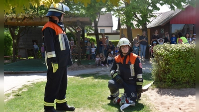 Wie die Feuerwehrleute bei der Übung eine Wasserversorgung aufbauten, interessierte die Mädchen und Buben des Kindergartens, die das Geschehen aus sicherer Entfernung verfolgten. (Foto: Erich Herrmann)