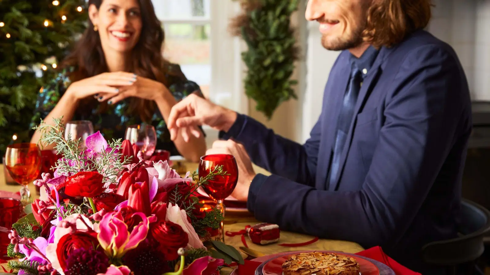 Stimmungsvoll dekoriert: Blumen auf der Festtafel und ein leuchtender Weihnachtsbaum ergänzen sich wunderbar. (Foto: tollwasblumenmachen.de/dpa-tmn)