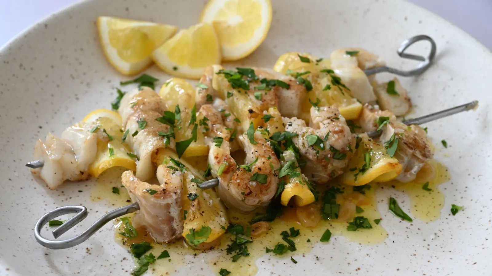 Fischstückchen und gefaltete Zitronenscheibchen werden abwechselnd aufgespießt, mit Knoblauchöl eingepinselt und gegrillt - fertig ist das Urlaubsfeeling.  (Foto: Julia Uehren/loeffelgenuss.de/dpa-tmn)