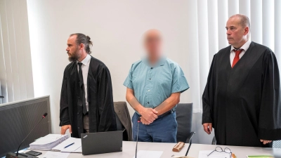Der Angeklagte aus dem Landkreis Forchheim (hier neben seinen Anwälten) soll eine 33 Jahre alte Prostituierte ermordet haben. Zum Prozessbeginn schwieg er. (Foto: Daniel Vogl/dpa)