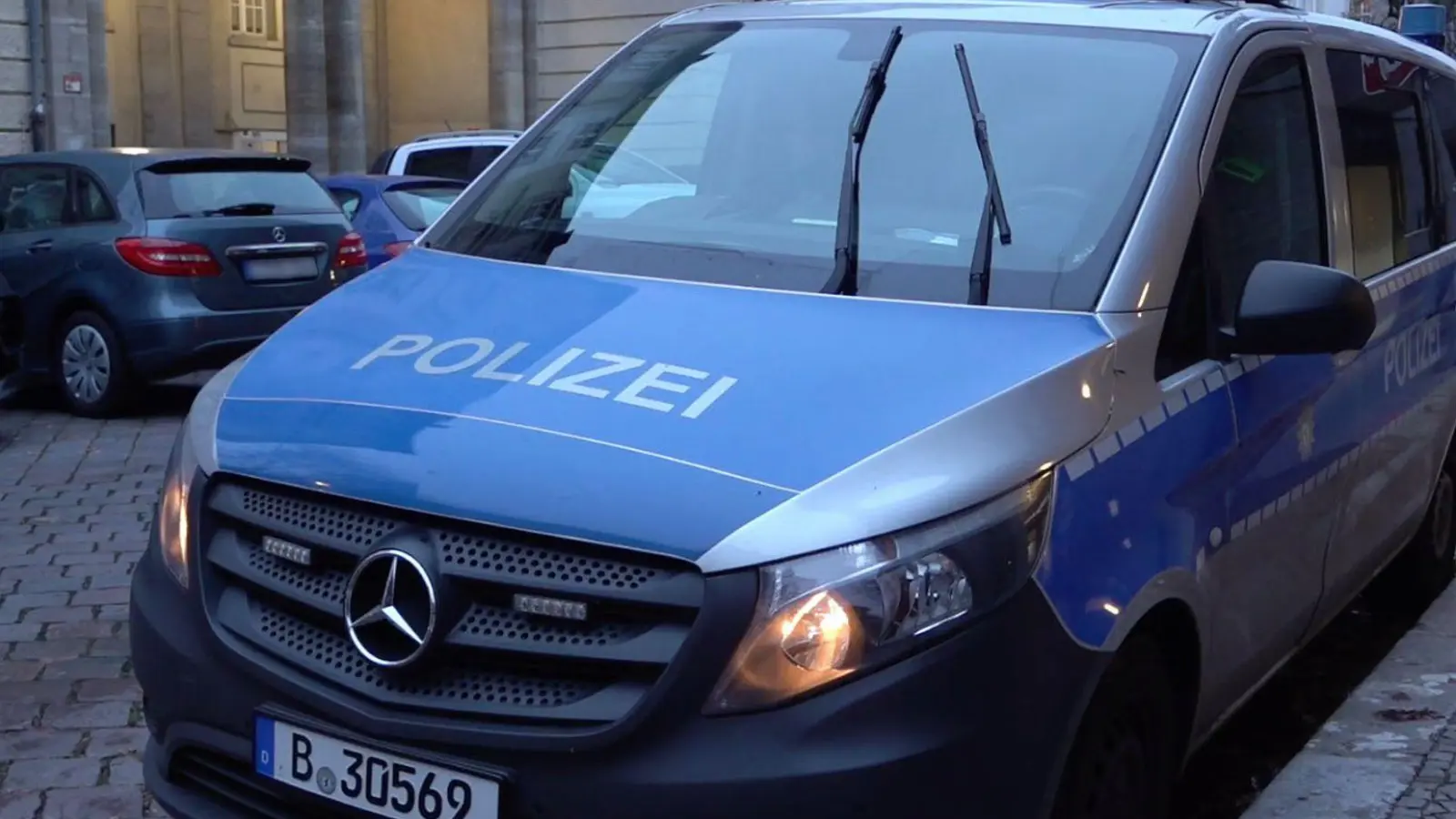 Ein Polizeiauto steht nach vermeintlichen Anschlagsandrohungen vor einer Berliner Schule. (Foto: Sven Käuler/dpa)