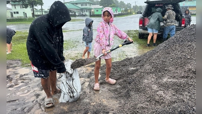 In Hawaii füllen Menschen Sandsäcke, um ihre Häuser vor den Auswirkungen von „Nolo“ zu schützen. (Foto: Eugene Garcia/AP/dpa)