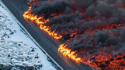 Nach einem erneuten Vulkanausbruch fließt Lava über die Hauptstraße nach Grindavík. (Foto: Marco Di Marco/AP/dpa)