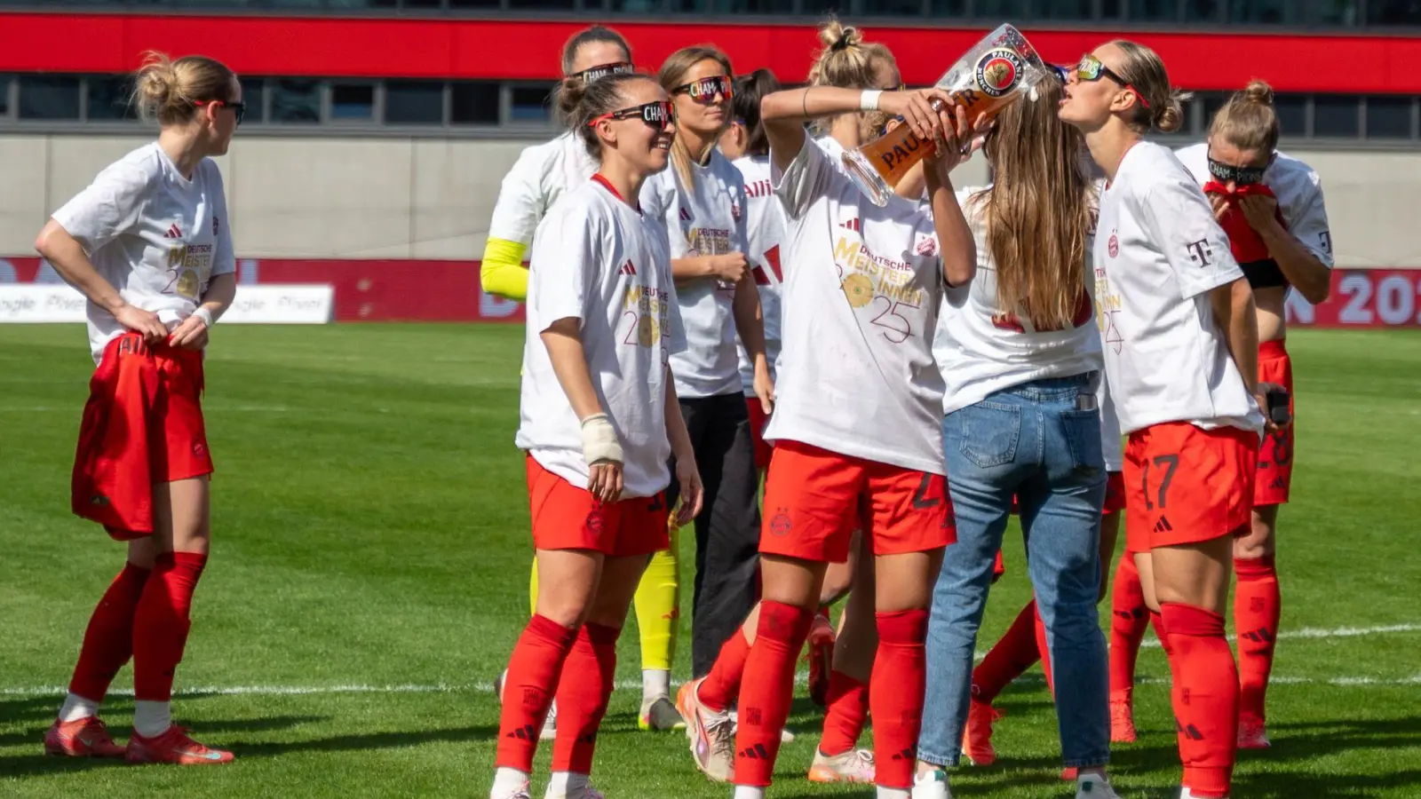 In Meister-Shirts und mit Bier feiern die Bayern-Fußballerinnen den Titel. (Foto: Leonie Asendorpf/dpa)