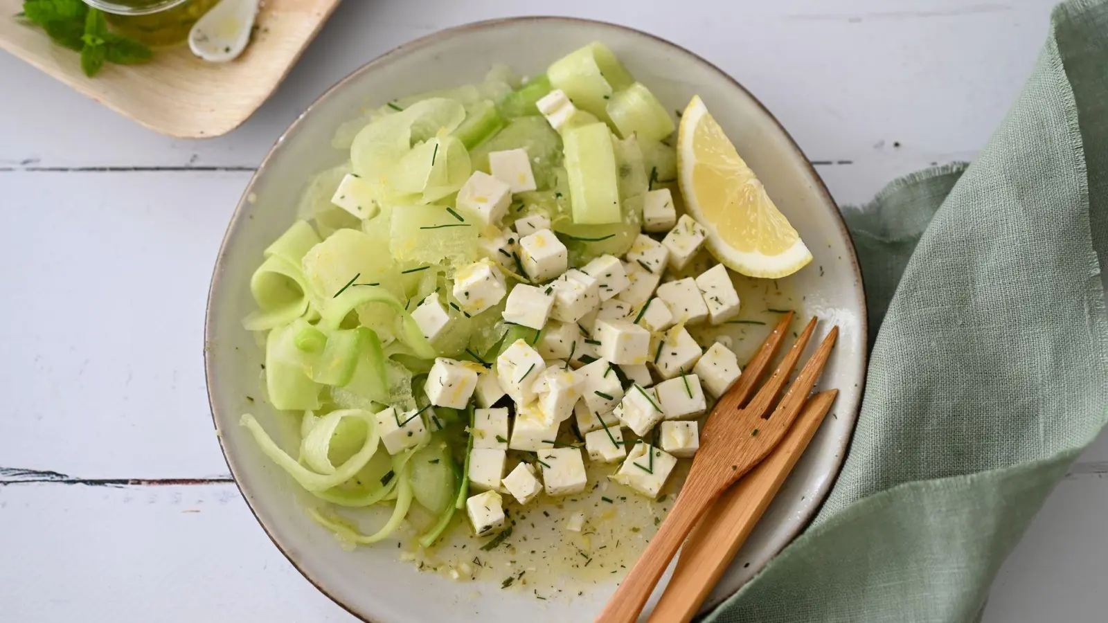 Mit dem Sparschäler gelingen hauchdünne Scheiben von der Honigmelone und Gurke. Sie geben dem Salat eine spezielle Textur. (Foto: Julia Uehren/loeffelgenuss.de/dpa-tmn)