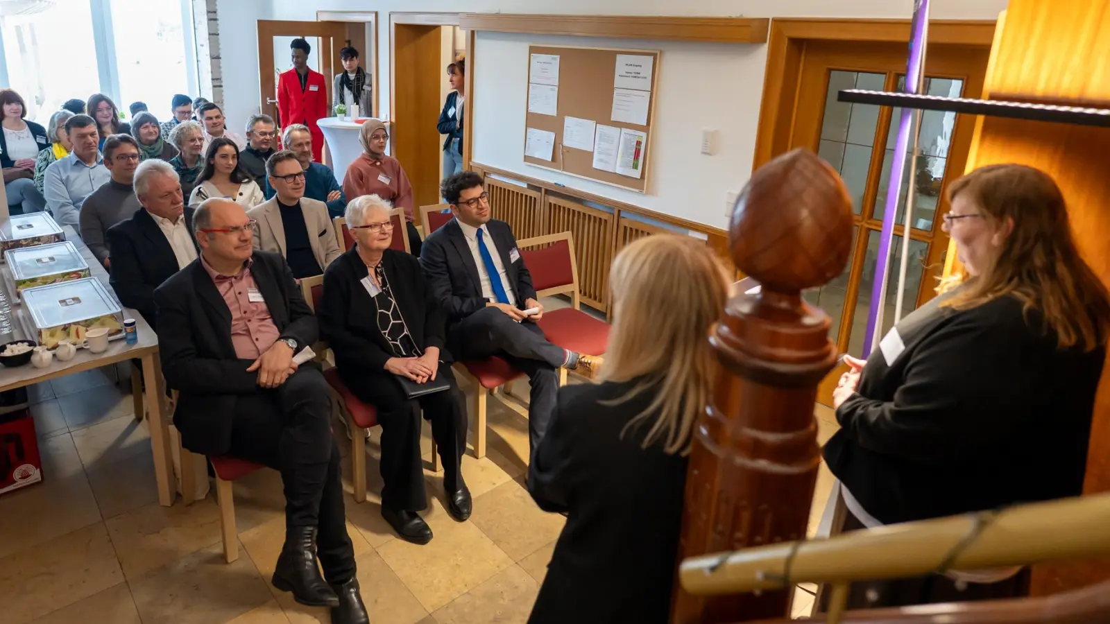 Andrea Pieczyk (rechts vorne, stehend) und Julia Bonengel (links daneben) begrüßten die Gäste bei der Eröffnungsfeier im teilzeitbetreuten Wohnen in Neustadt. (Foto: Mirko Fryska)