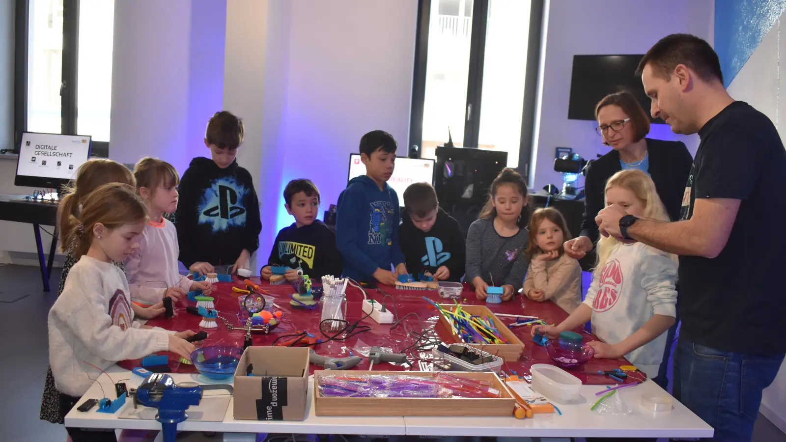 Bernd Böhm erklärt den Kindern den Bau von kleinen Bürstenrobotern. Die Mädchen und Jungen fertigen aus Zahnbürsten, Dekorationsmaterial und einem Elektromotor fantasievolle Gebilde. (Foto: Ute Niephaus)