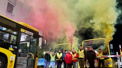 Zum Auftakt des zweitägigen Warnstreiks beim Berliner Nahverkehr halten streikende BVG-Mitarbeiter Leuchtfackeln und machen damit bunten Qualm. (Foto: Michael Ukas/dpa)