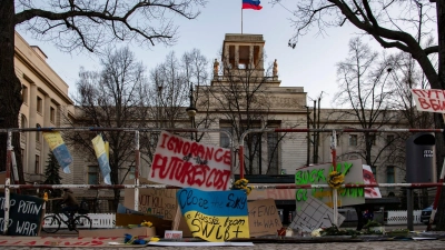 An den Absperrgittern vor der russischen Botschaft in Berlin haben Menschen Plakate angebracht. (Foto: Paul Zinken/dpa)