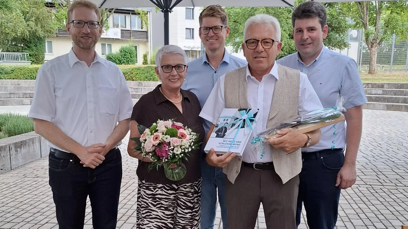 Dekan Max von Egidy, Ingrid Bauer, Gesamtschulleiter Philipp Specht, Friedrich Bauer und Geschäftsführer Christoph Kilian bei der Übergabe des Fotobuchs „Mit Herz und Schlüsselbund“ (von links). (Foto: Ralf Lischka)