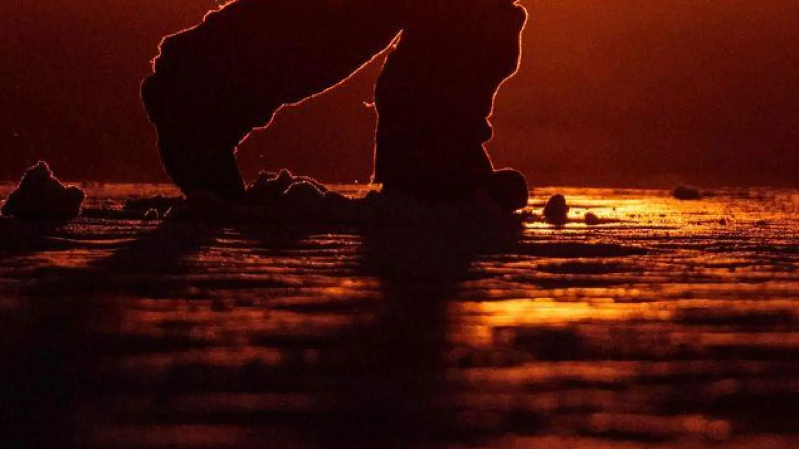 Ein Junge läuft bei Sonnenuntergang über eine Straße in Nuuk in Grönland. (Foto: Evgeniy Maloletka/AP/dpa)