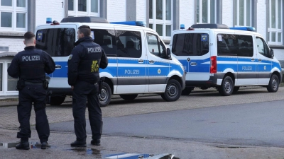 Polizisten stehen vor einem Gebäude, das durchsucht wird. (Foto: Gianni Gattus/dpa)