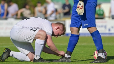 Mit der Ausrüstung muss alles in Ordnung sein: Der Herrieder Danny Schuster zurrt seinem Torwart Fabian Horn die Schnürsenkel fest. (Foto: Martin Rügner)