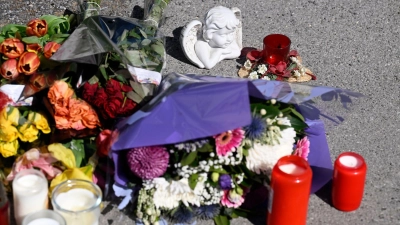 Zeichen der Anteilnahme: Auf einem Bürgersteig an dem Spielplatz sind Kerzen und Blumen niedergelegt worden. (Foto: Roberto Pfeil/dpa)